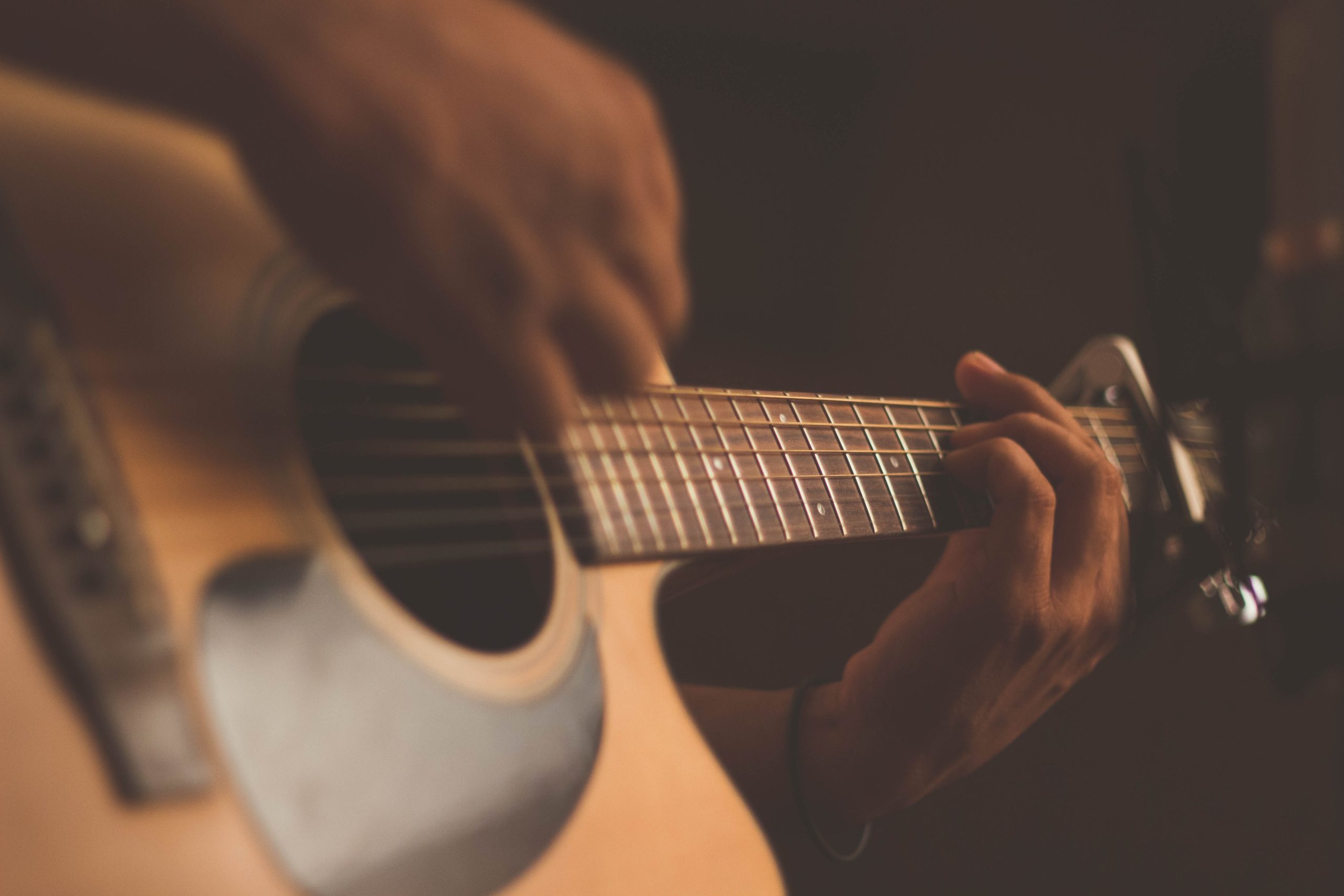 close up of a man learning to play the guitar
